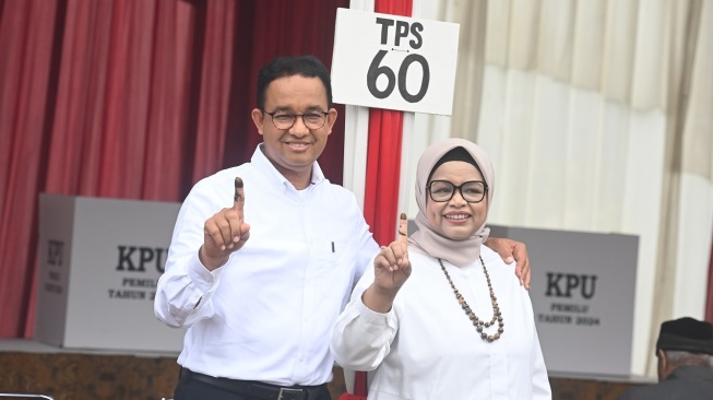 Capres nomor urut 1 Anies Baswedan (kiri) bersama istrinya Fery Farhati menunjukkan jari yang telah dicelup tinta usai melakukan pencoblosan Pemilu 2024 di TPS 60, Lebak Bulus, Jakarta, Rabu (14/2/2024). [ANTARA FOTO/Indrianto Eko Suwarso].